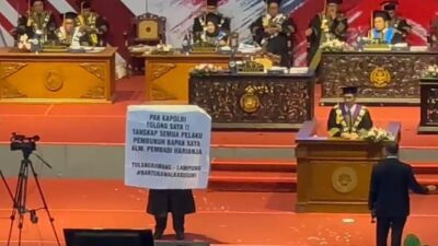 Mahasiswa Lampung Membentangkan Spanduk saat Wisuda dan Meminta Kapolri untuk Menangkap Semua Pembunuh Bapaknya