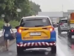 Perempuan Berjalan Sendirian di Tol Jakarta-Merak Saat Hujan